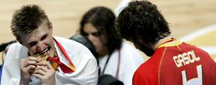 Russia's Kirilenko bites his gold medal beside Spain's Gasol after winning the final game against Spain at the European Basketball Championships